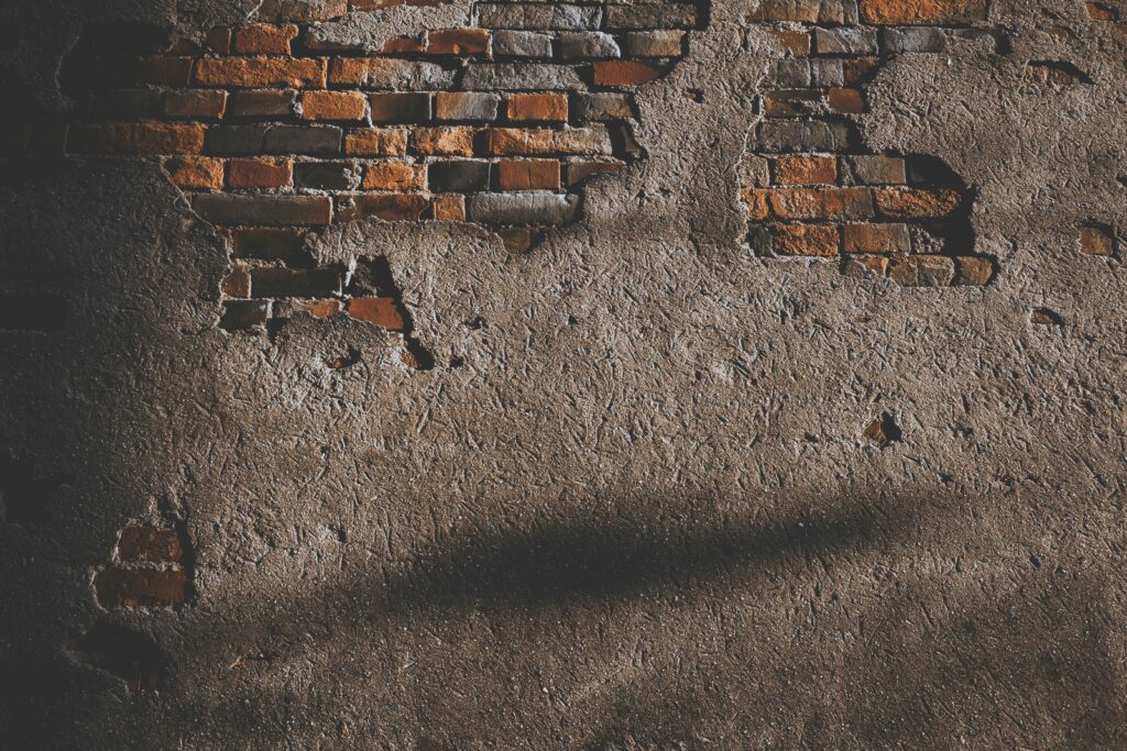 A vintage brick wall with exposed texture, ideal for background use.