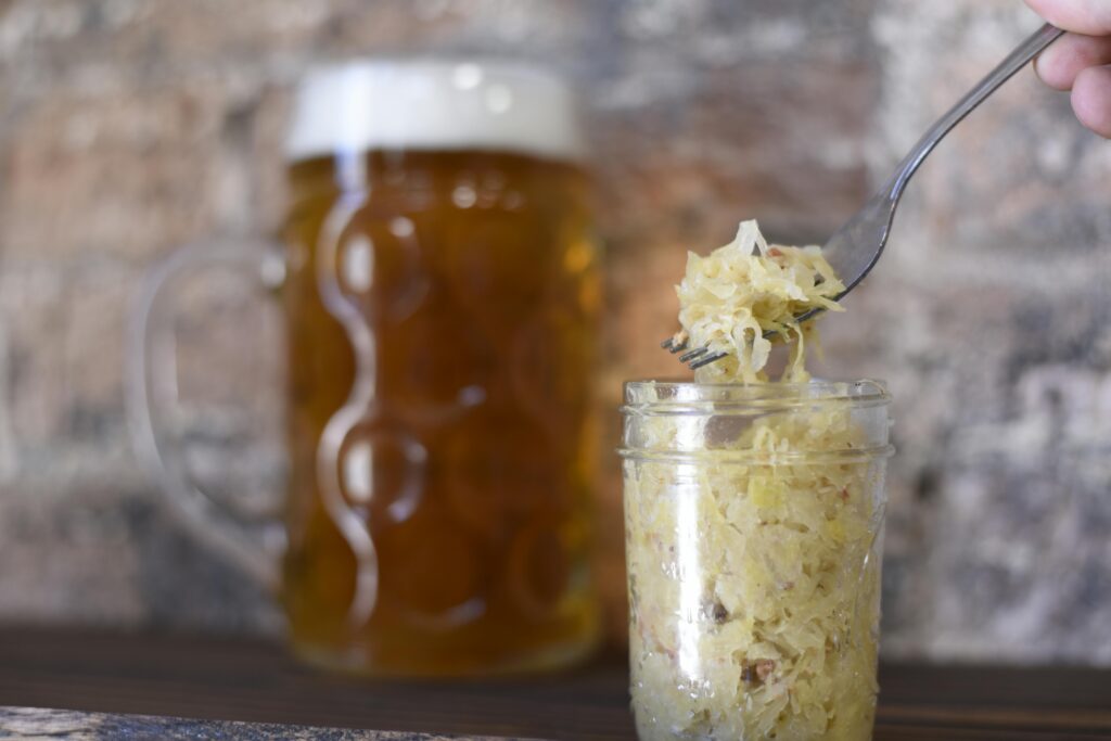 A rustic setting featuring a frothy beer mug and sauerkraut in a jar, perfect for pub themes.