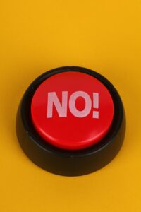 A bold red "No!" button set against a vivid yellow backdrop.